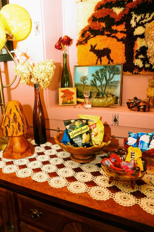 Decor table with deer tapestry, snack bowls, and vintage lamps